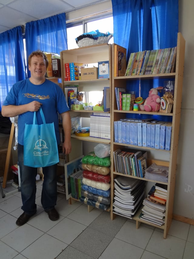 Rev. Omar Kinas happily posing with the church's new library