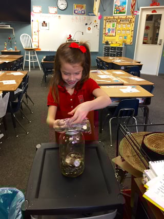 A Salem student changing the world by adding her change to her class's jar. A Salem student changing the world by adding her change to her class's jar.