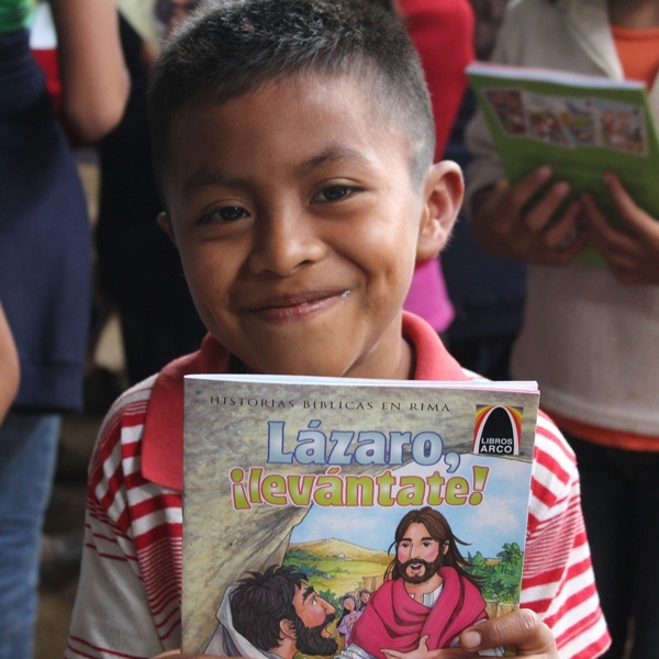 A young boy very happy to have his own copy of Lazaro, ¡levántate!